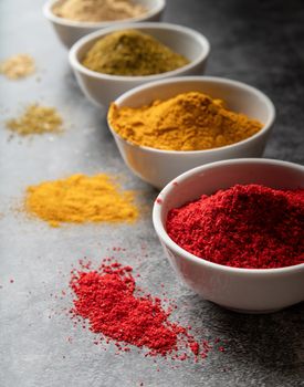 Healthy food. Colorful indian spices in small bowls on dark concrete background