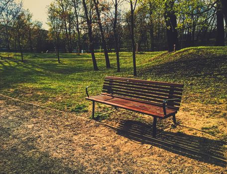 Empty bench in park during a city lockdown in coronavirus pandemic, outdoors and social issue