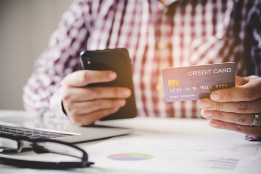 Woman holding credit cards and mobile phones are now shopping over the internet by paying by credit card.