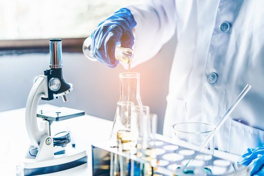  Equipment and science experiments oil pouring scientist with test tube yellow making research in laboratory.