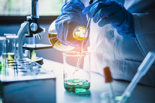  Equipment and science experiments oil pouring scientist with test tube yellow making research in laboratory.