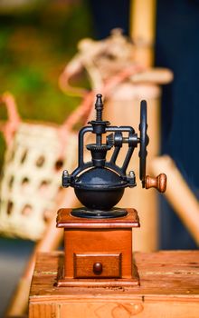 Antique coffee grinder placed on a wooden table