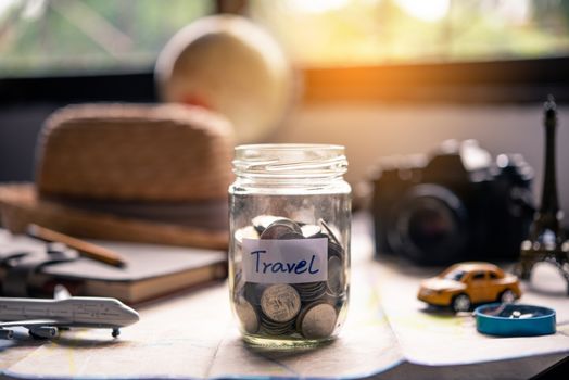 The money in the jar stored on the map, along with a passport, concept to collect money for travel.