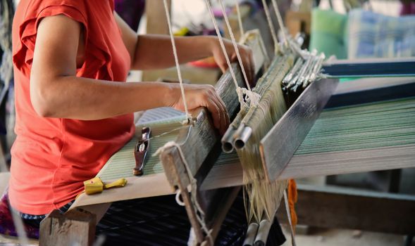 The hand of a weaver is woven with a hand-woven machine.