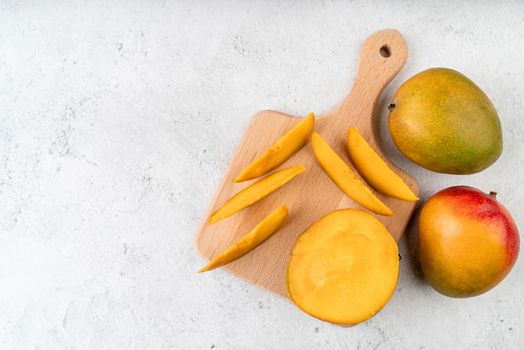 sliced mando fruit on a wooden cutting board flat lay top view on marble background with copy space