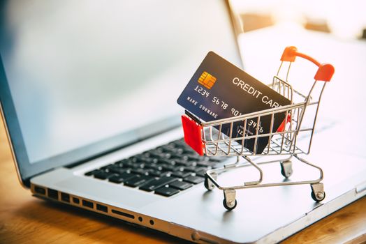 Small shopping cart with credit card on laptop, online shopping and shopping concept