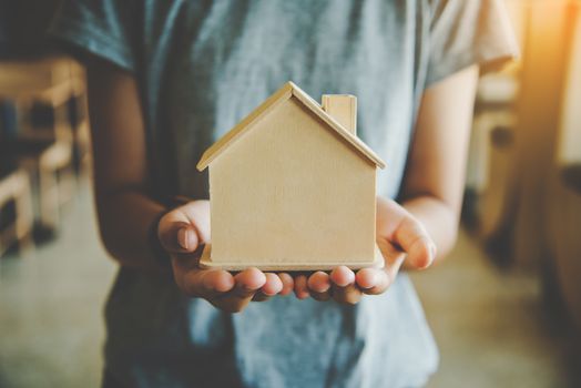 Hand with model house extended