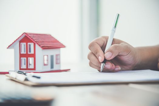 Close up hand  signing signature loan document to home ownership. Mortgage and real estate property investment, home insurance ,security 