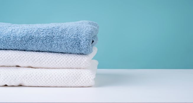 Laundry concept. Stack of clean towels on blue background