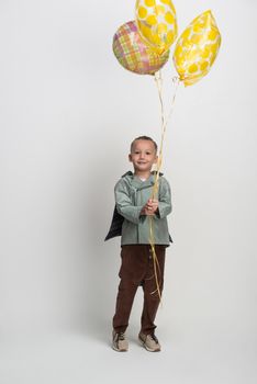 happy little boy with balloon on white background, studio shot