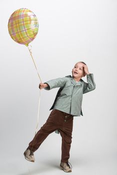 happy little boy with balloon on white background, studio shot