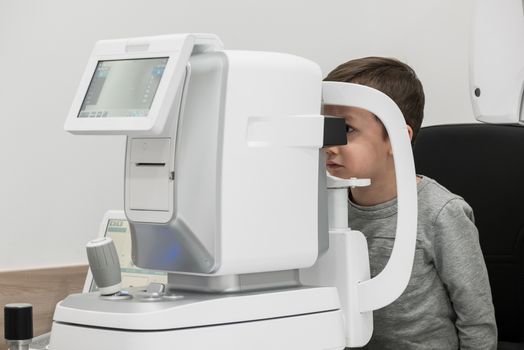 the boy is the patient on reception at doctor ophthalmologist. diagnostic ophthalmologic equipment. medicine concept