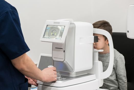 the boy is the patient on reception at doctor ophthalmologist. diagnostic ophthalmologic equipment. medicine concept