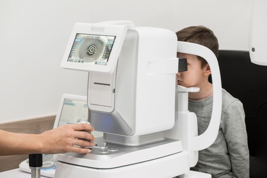 the boy is the patient on reception at doctor ophthalmologist. diagnostic ophthalmologic equipment. medicine concept