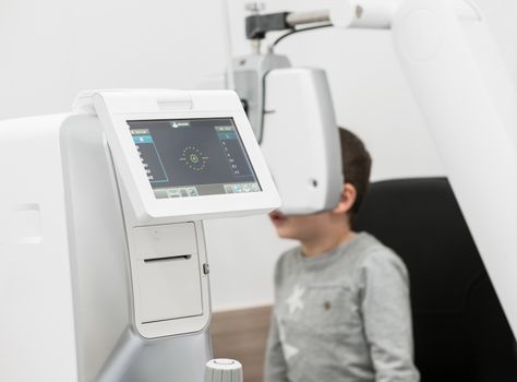 the boy is the patient on reception at doctor ophthalmologist. diagnostic ophthalmologic equipment. medicine concept