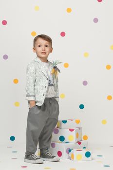 little boy in the trendy and designer suits and sneakers on a white background