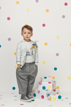 little boy in the trendy and designer suits and sneakers on a white background