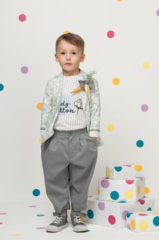 little boy in the trendy and designer suits and sneakers on a white background