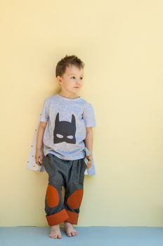 little boy in a suit with the image of Batman on a light yellow background