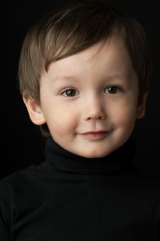 portrait of a little boy on a dark background