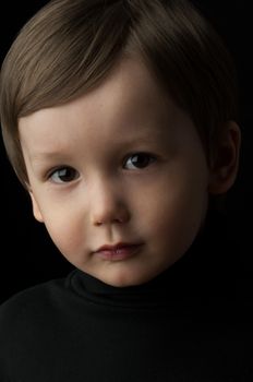 portrait of a little boy on a dark background