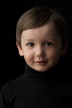 portrait of a little boy on a dark background