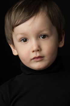 portrait of a little boy on a dark background