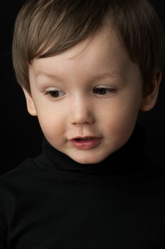 portrait of a little boy on a dark background