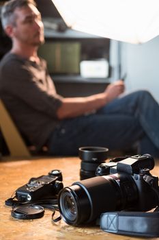 camera and equipment on the table in the Studio in the background of the sitting photographer