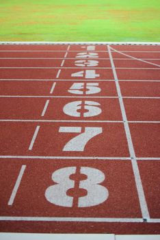 Athlete running track with number on the start . Perspective

