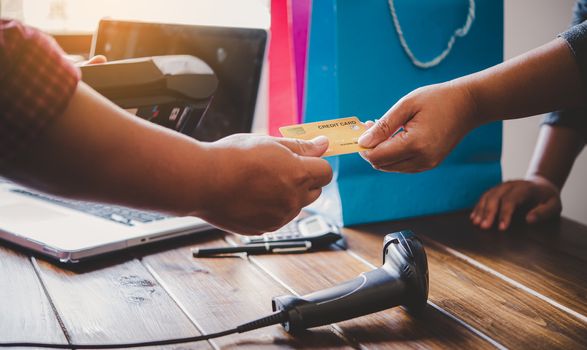 Close up of hand using credit card to pay by sending the credit card to the staff at the credit card swipe machine. Online payment