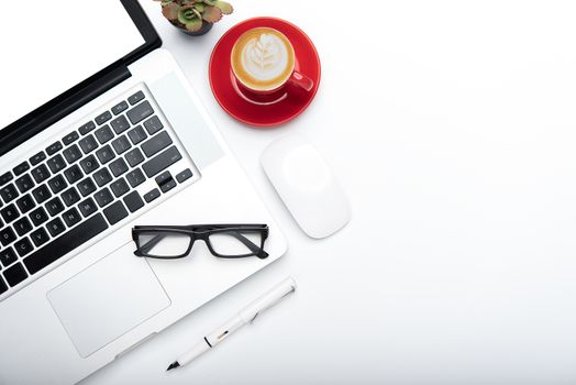 Top view with working desk with laptop,cellphone,notebook pencil coffee cup and eyeglasses in the office. 