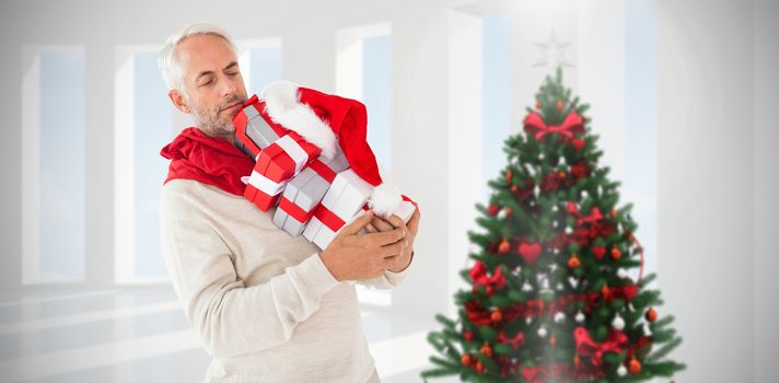 Happy festive man with gifts against home with christmas tree
