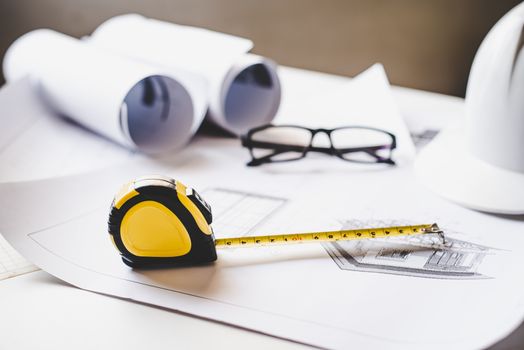  tape measure is placed on the work table with a house plan designed Including engineering equipment