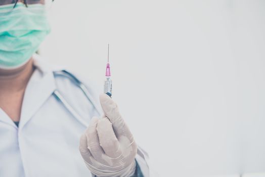 Doctor with syringe ready for injection of vaccine to patient. Vaccination concept.