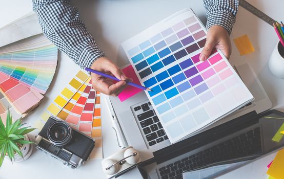 The graphic designer creative team is currently working on the design and color selection on the guide color for advertising design.