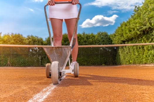 tennis player marks a lime white line on a tennis court. copy space.