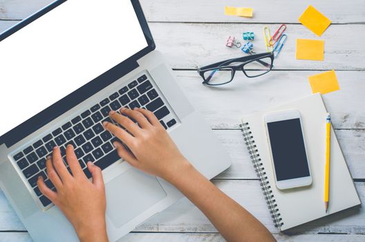 The top view is a close-up business process that works with laptops and has cell phones and coffee mugs placed on a desk in the office.