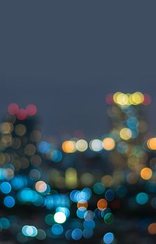 Vertical cover of blurred bokeh cityscape at twilight time, city background, aerial view angle from rooftop ob building, defocused city in downtown,graphic design for web online or book vertical cover