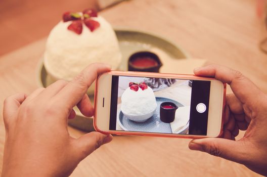 People using smartphones take photo sitting at the cafe comfortable