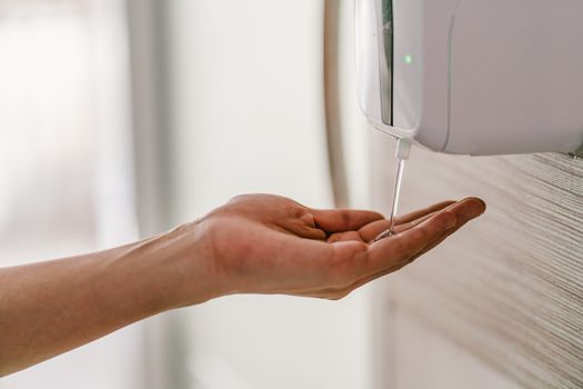 Closeup Asian woman hand using wash hand sanitizer gel dispenser automatic machine before work while Coronavirus Network Outbreak, health care and cleaning for prevent covid19 concept