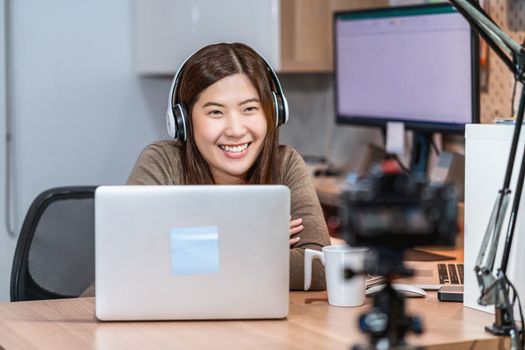 Asian business woman using technology laptop and working from home in home offuce, freelance and entrepreneur, camera taking video of vlooger or influence Live, social distance and self responsibility