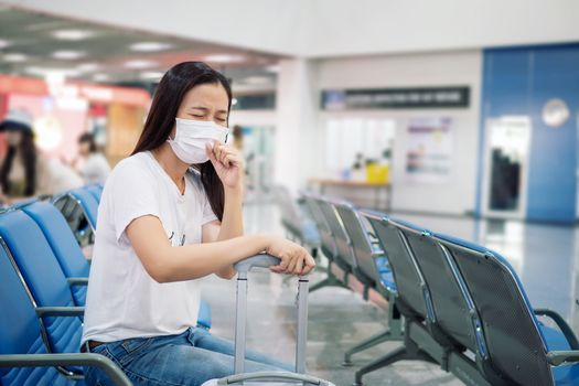 Asian tourist feeling sick, coughing ,wearing mask to prevent during travel time at the airport terminal for protect from the new Coronavirus 2019 infection outbreak situation