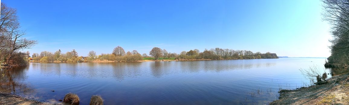 Beautiful high resolution panorama of a northern european country landscape with fields and green grass.