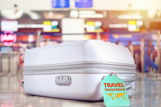 travel bag at the airport with travel insurance tag on suitcase holder for cover delay or lost luggage, trip cancellation, accident, losses, etc to protection your trip.