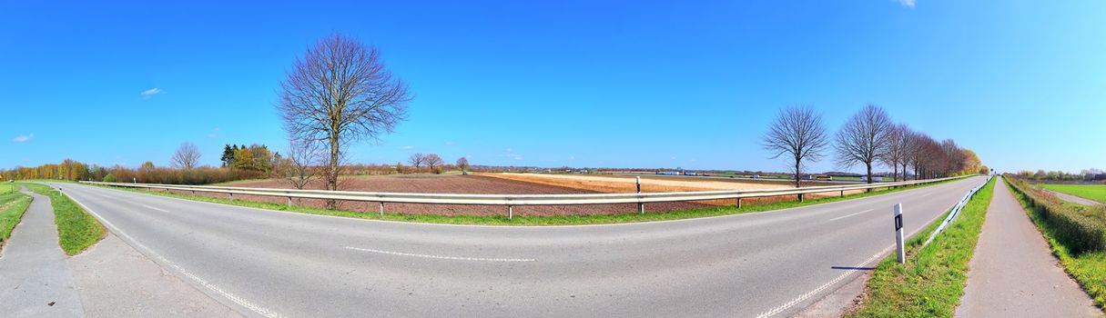 Beautiful high resolution panorama of a northern european country landscape with fields and green grass.