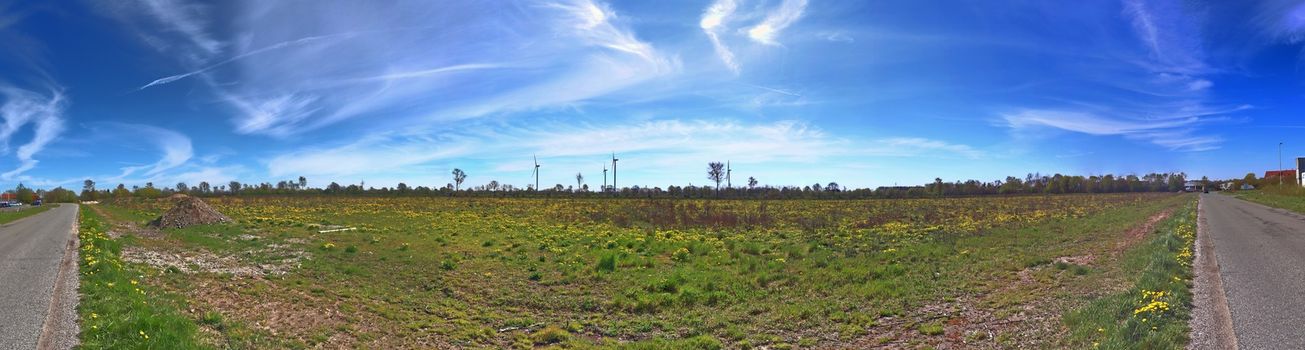 Beautiful high resolution panorama of a northern european country landscape with fields and green grass.