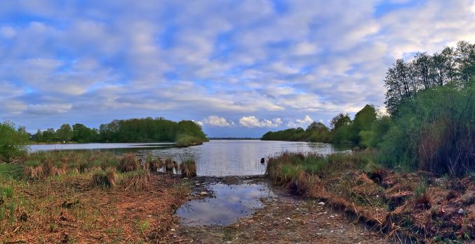 Beautiful high resolution panorama of a northern european country landscape with fields and green grass.