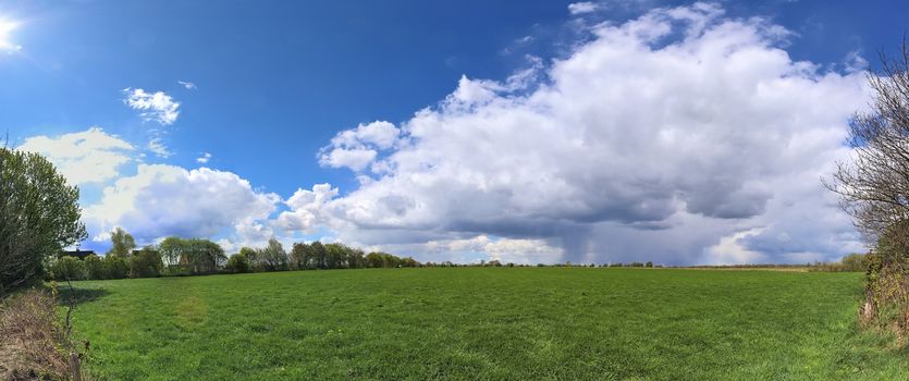 Beautiful high resolution panorama of a northern european country landscape with fields and green grass.