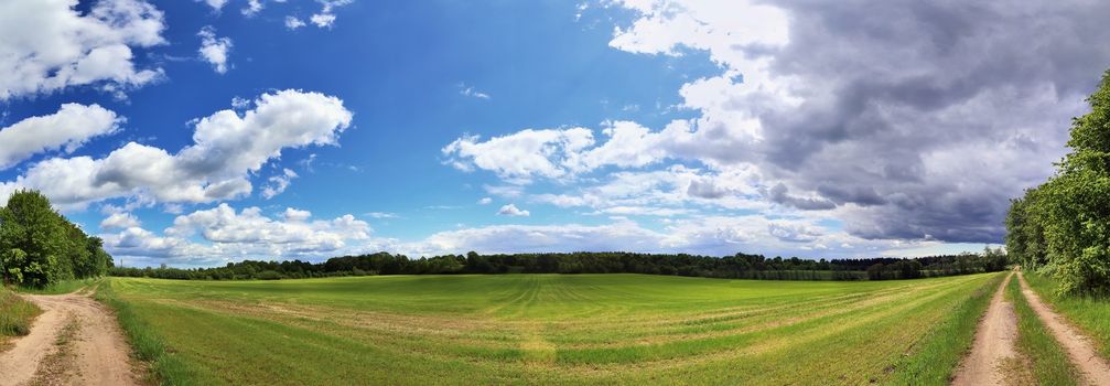 Beautiful high resolution panorama of a northern european country landscape with fields and green grass.